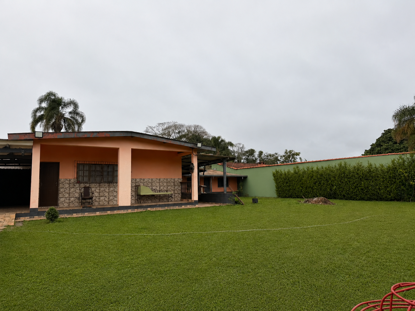 Área externa da chácara com gramado amplo e casa ao fundo